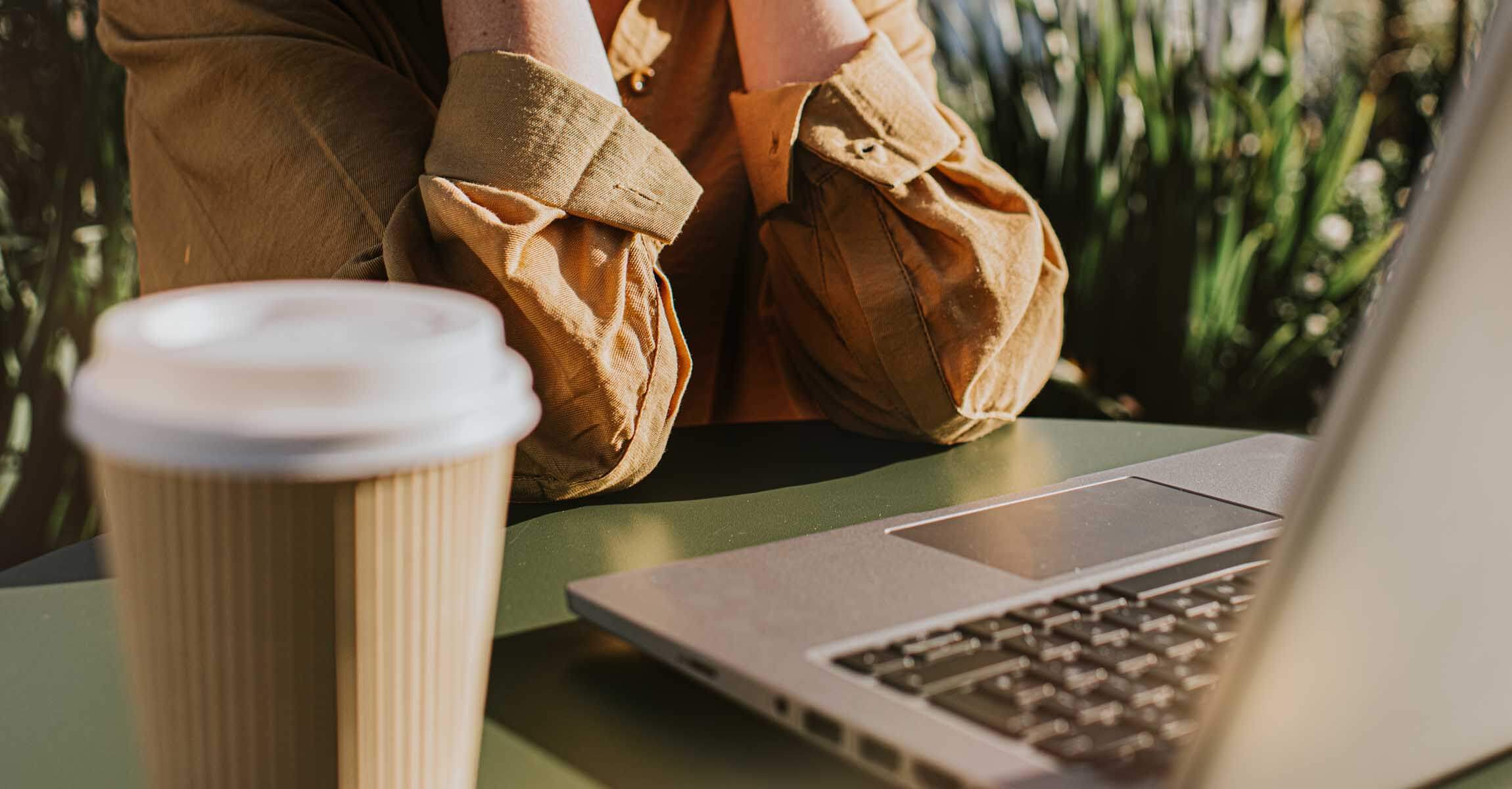 Woman sat at laptop with coffee