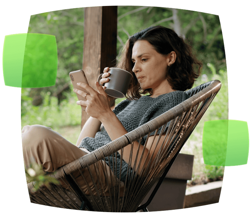 woman in outdoor chair drinking from a mug