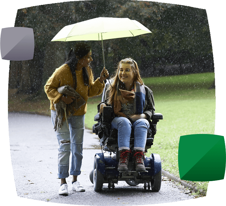friends in the rain, one walking and one in an electric wheelchair, sharing an umbrella