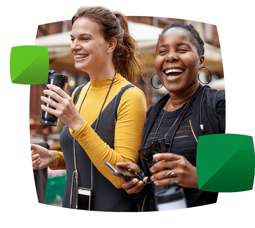 Women holding a drink and a phone having fun